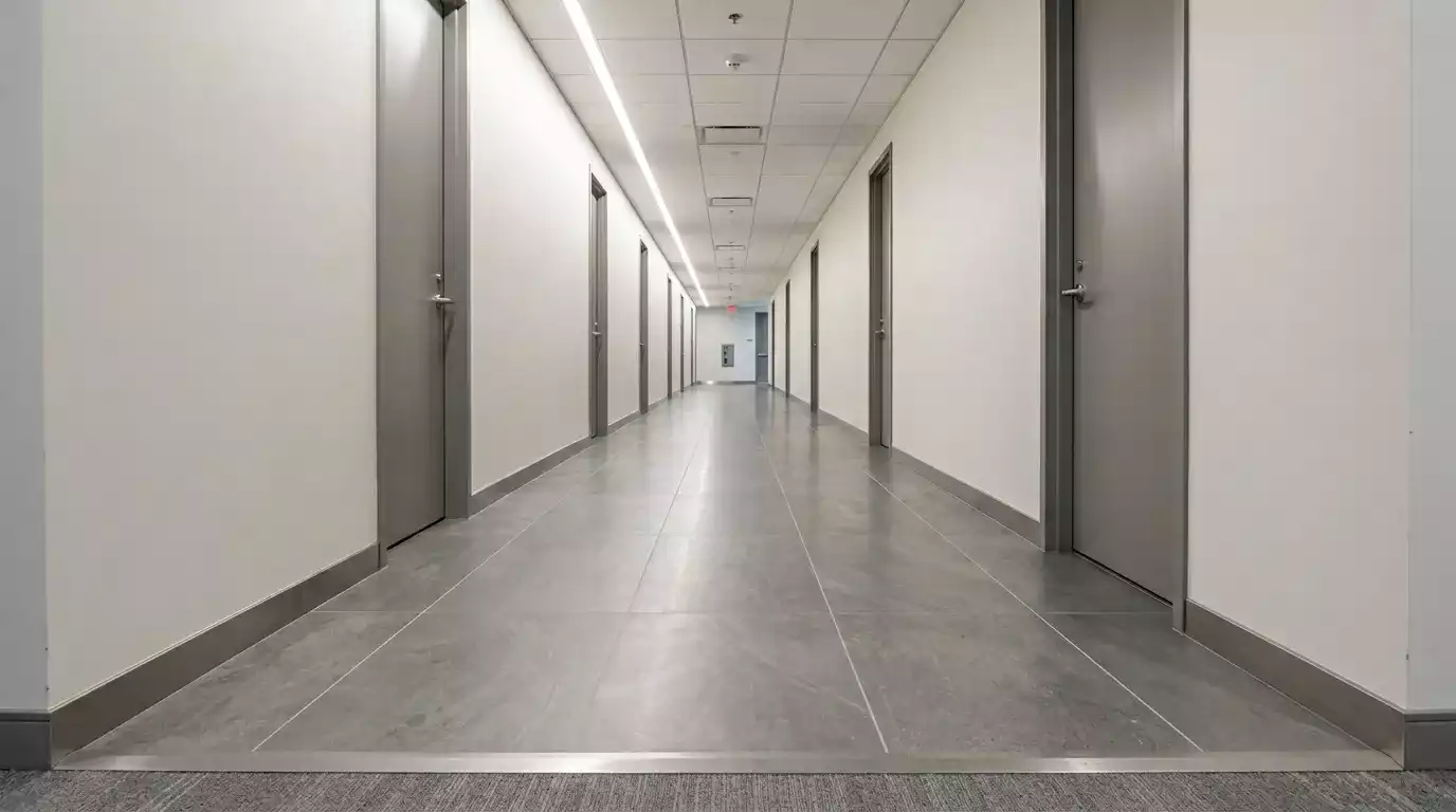 Detalhe de rodapés e perfis de transição entre piso vinílico e boiserie